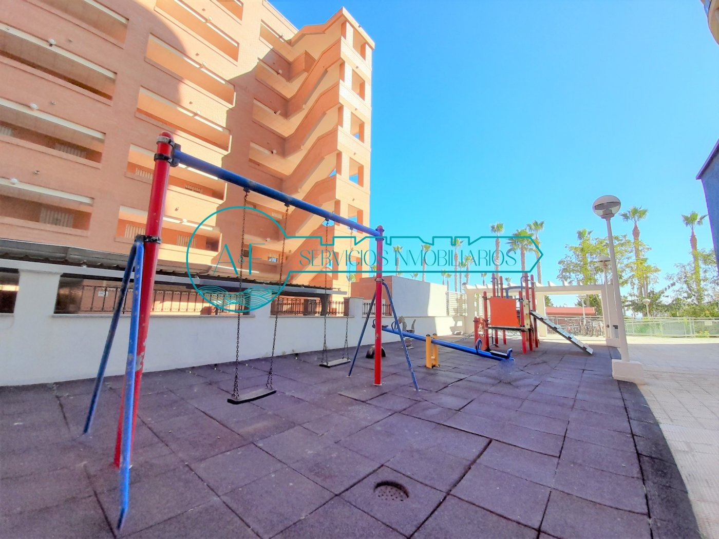 Ejemplo de un apartamento en Oropesa del Mar con vistas al mar con zona comunitaria. Fotografía de patio exterior comunitario con parque infantil con columpios, balanzas y juegos. A yF Inmobiliaria Oropesa del Mar encuentra pisos de alquiler vacacionales