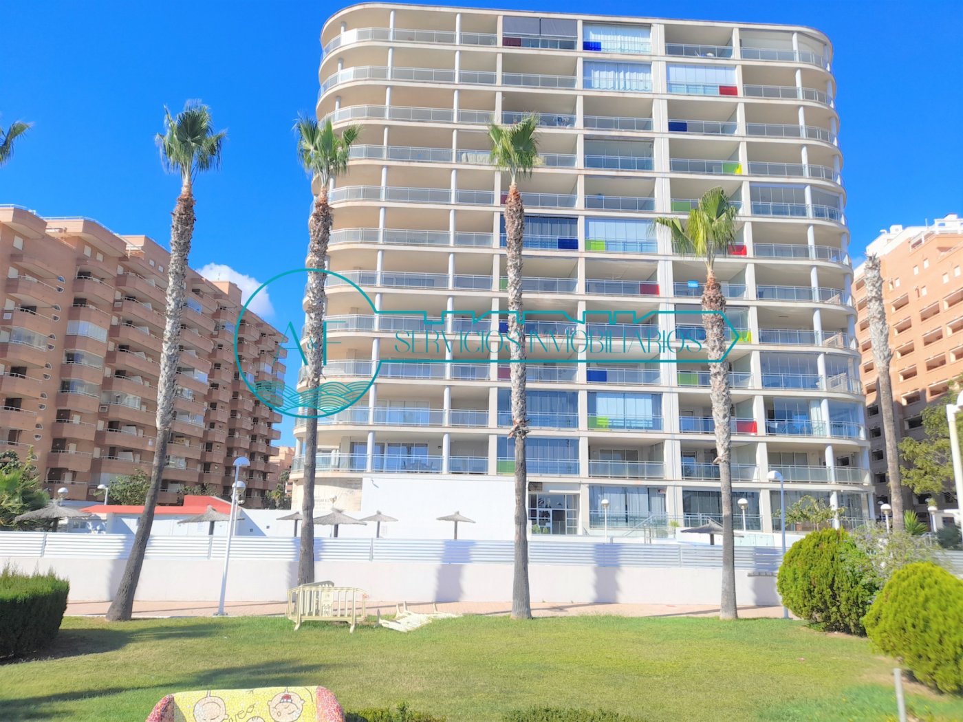 Ejemplo de un apartamento en Oropesa del Mar con vistas al mar con zona comunitaria. Fotografía del bloque de apartamentos visto por fuera desde el parque. Ay F Inmobiliaria Oropesa del Mar pisos de alquiler para vacaciones